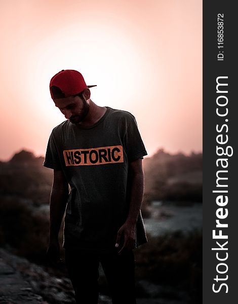 Man Wearing Gray T-shirt and Red Fitted Cap