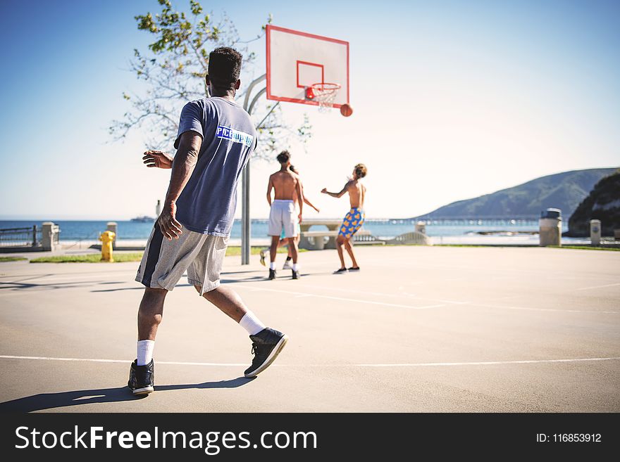 Four People Playing Basketball