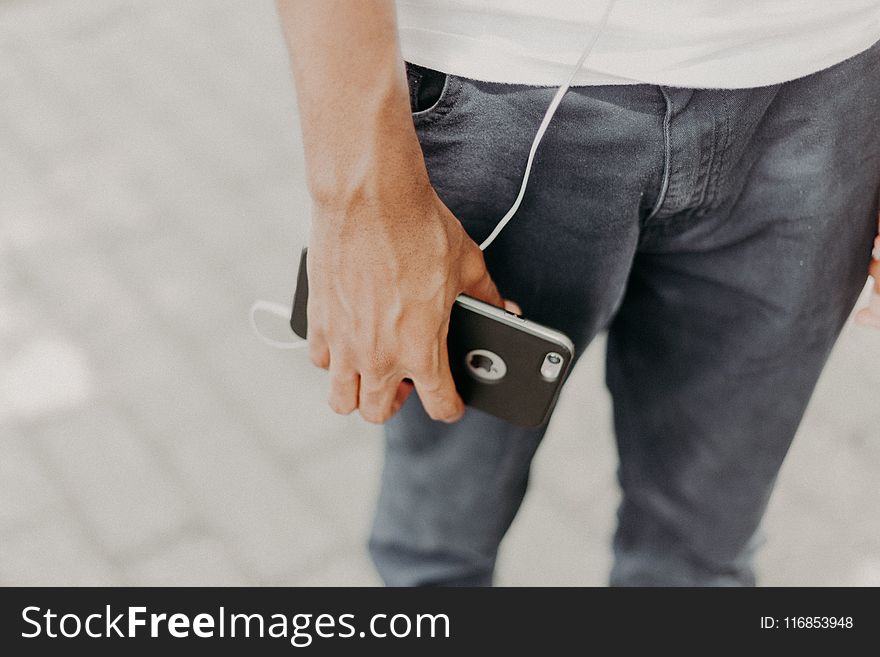 Person Holding Iphone With Black Case