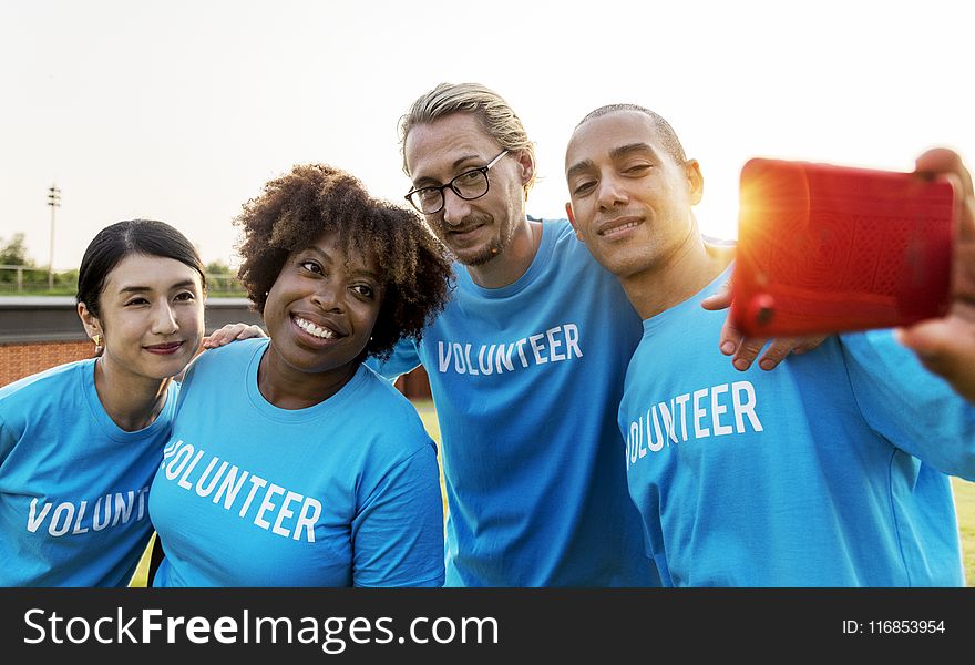 Group of People Wearing Blue Volunteer Shirts