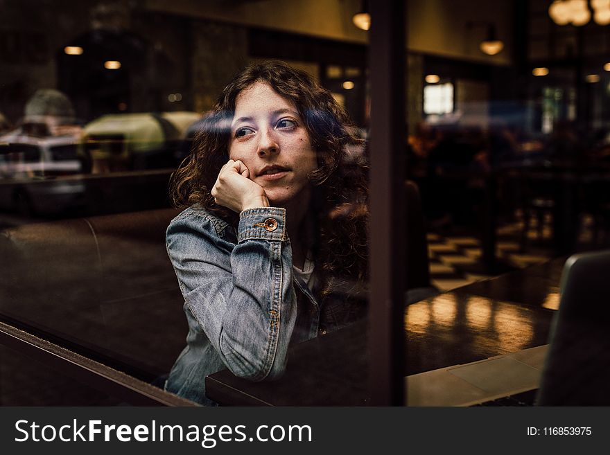 Woman Wearing Blue Denim Jacket Putting Her Right Arm on Her Cheek