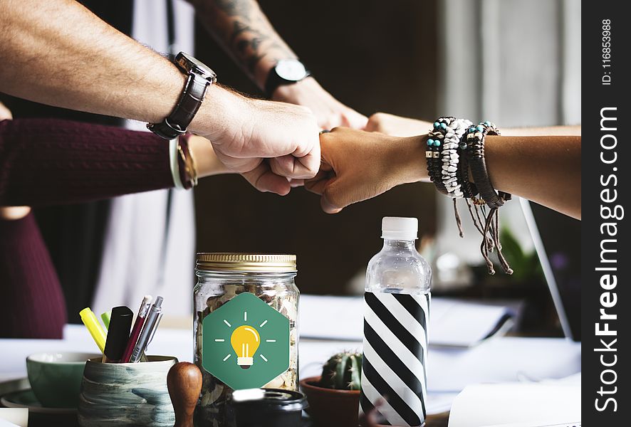 Group of People Putting Fist on Center