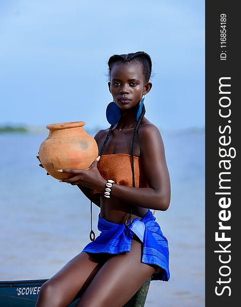 Woman Sitting on Boat Holding Brown Clay Pot