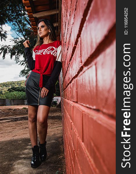 Woman Leaning On Wall Wearing Coca-cola Printed Top