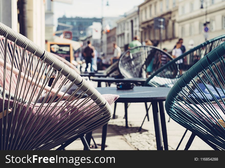 Selective Focus Photography of Patio Set Near Walking People