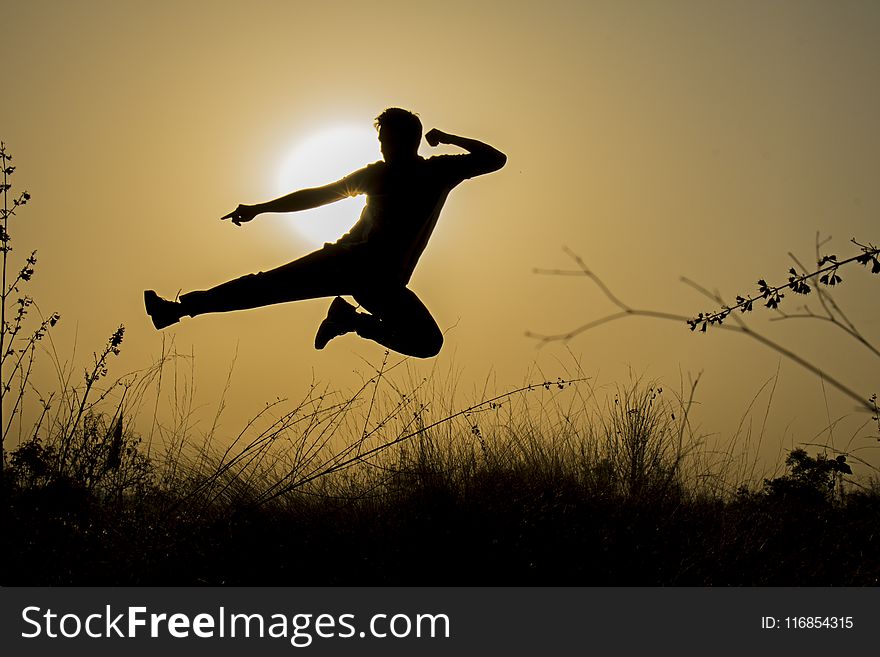 Silhouette of Man Doing Kick Jump during Sunset