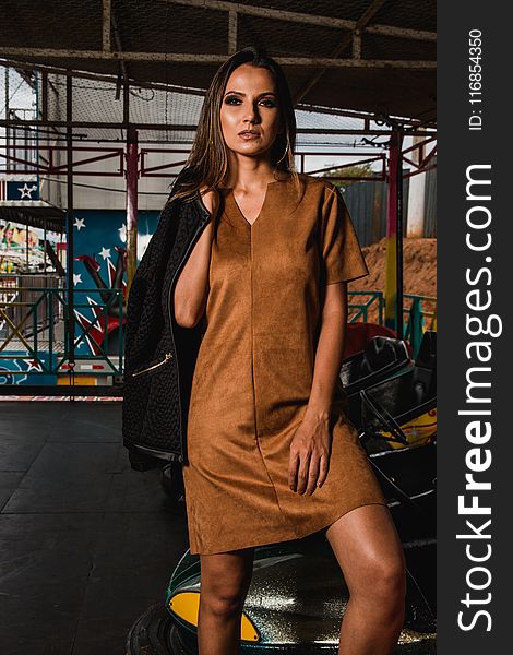 Photo Of Woman In Brown Mini Dress Holding Black Jacket