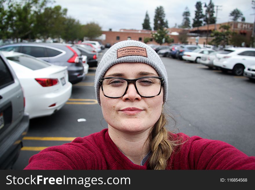Woman Taking Photo Of Herself Near Parked Vehicles