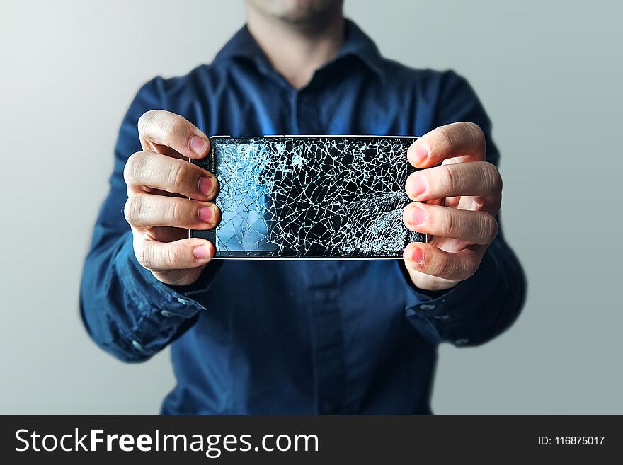 Bearded Upset Man Holds A Out-of-use Tablet Or Smartphone