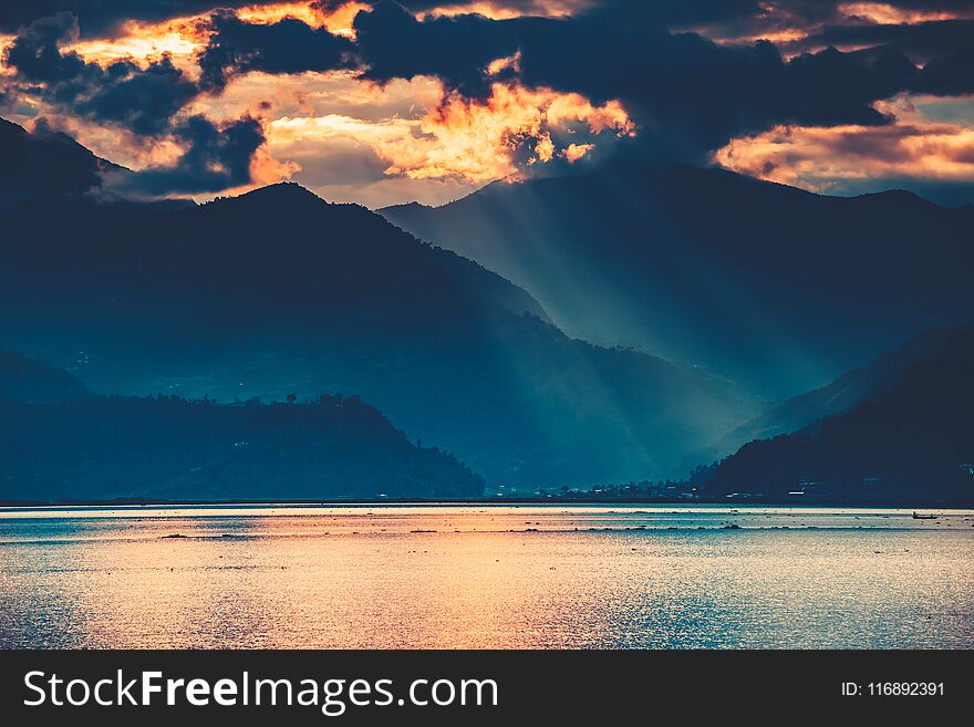 The amazing fairy tale sunset over the freshwater Phewa Lake. The breathtaking colorful cloudy sky. The main tourist attraction of Pokhara city in Nepal. The amazing fairy tale sunset over the freshwater Phewa Lake. The breathtaking colorful cloudy sky. The main tourist attraction of Pokhara city in Nepal.