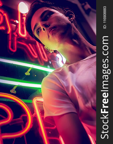 Young Man, Lit By Neon Light At Night.