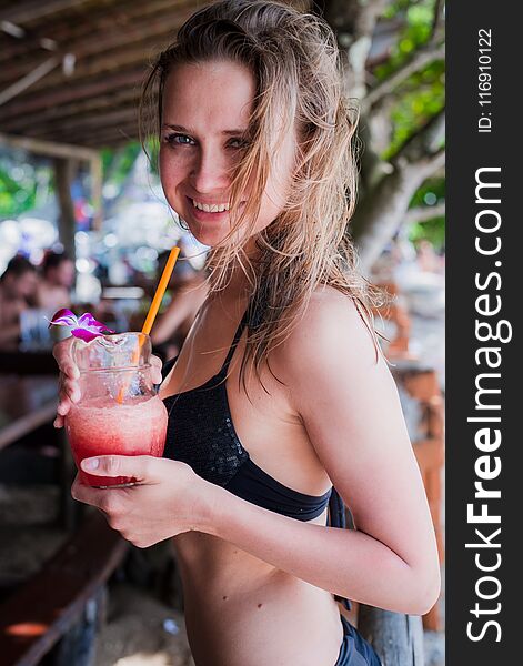 Sport fitness woman drinking healthy pink detox juice, vegetable smoothie on the beach summer outdoors. Fitness healthy