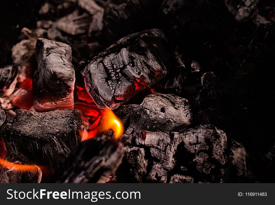 Flaming coals on bbq grill, closeup.