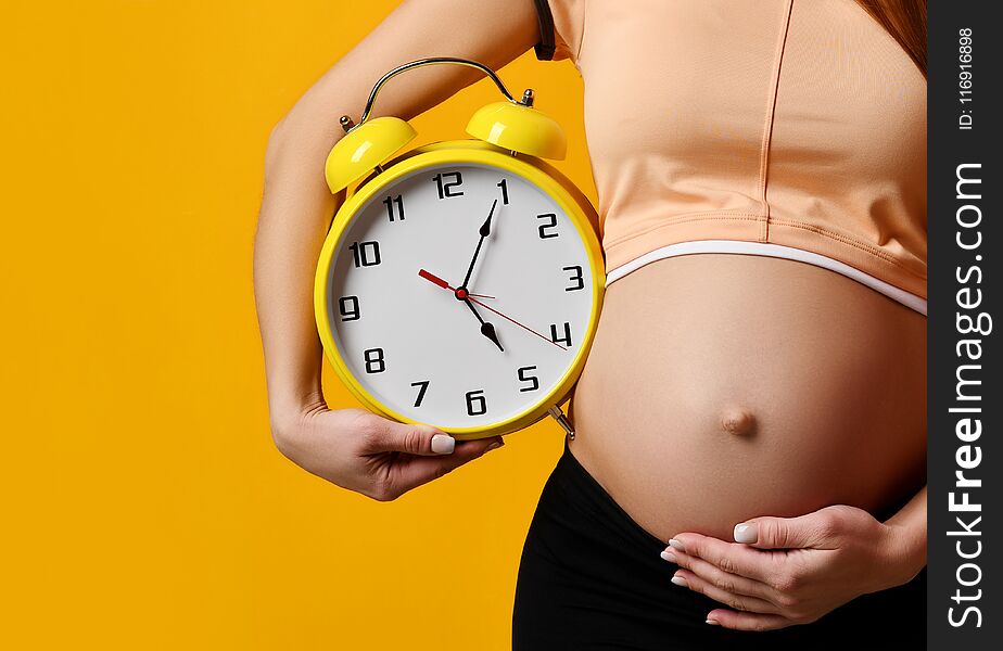 Pregnant Woman In Top Shirt Hold Big Clock Watch Smiling On Yellow