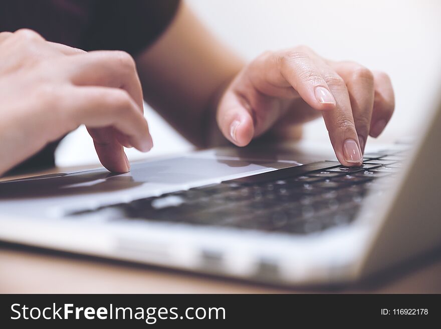 Hands Working And Typing On Laptop Keyboard With Blur Background