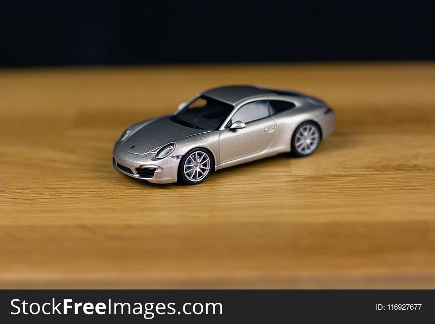 Shallow Focus Of Silver Die-cast Model On Brown Wooden Board