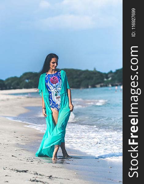 Woman in Blue and Pink Floral Monokini Standing at the Seashore