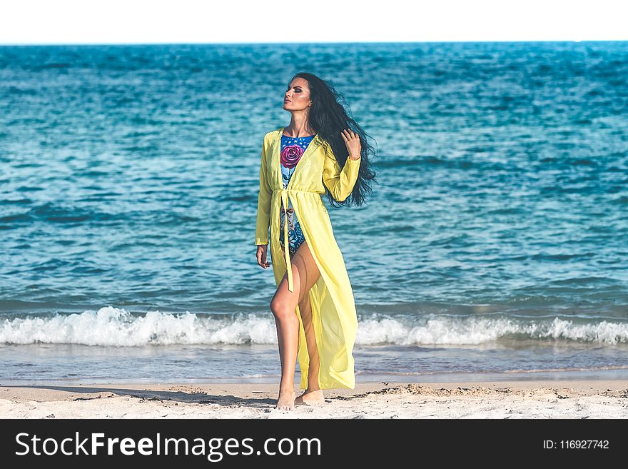 Woman Wearing Blue Monokini Standing on Beach Sand