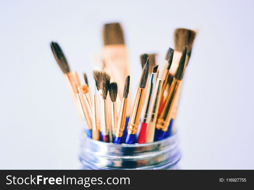 Shallow Photography Of Brushes On Jar