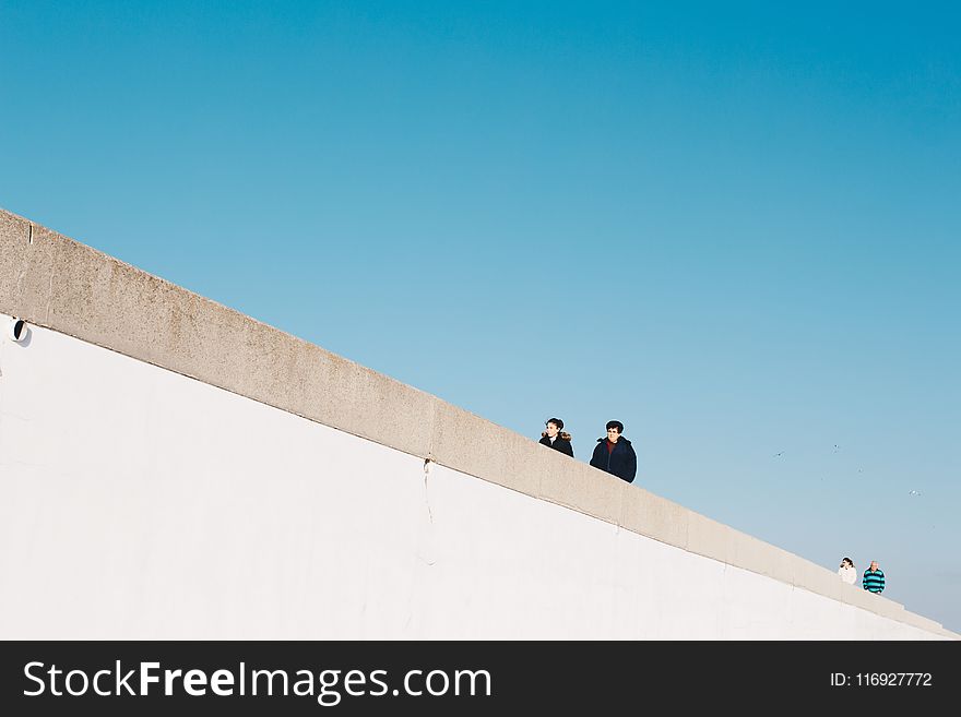 Four Person Wearing Jacket Under White Cloud Blue Skies