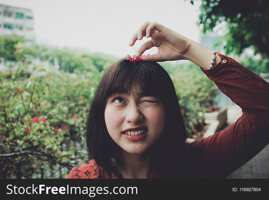 Woman Wearing Red Long-sleeved Shirt With Red Petaled Flower on Head