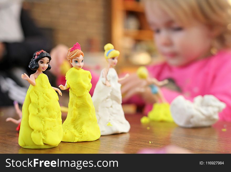 Selective Focus Photography of Three Disney Princesses Figurines on Brown Surface