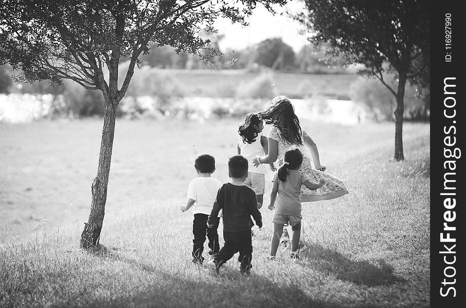 Grayscale Photo of Five Children Near Tree