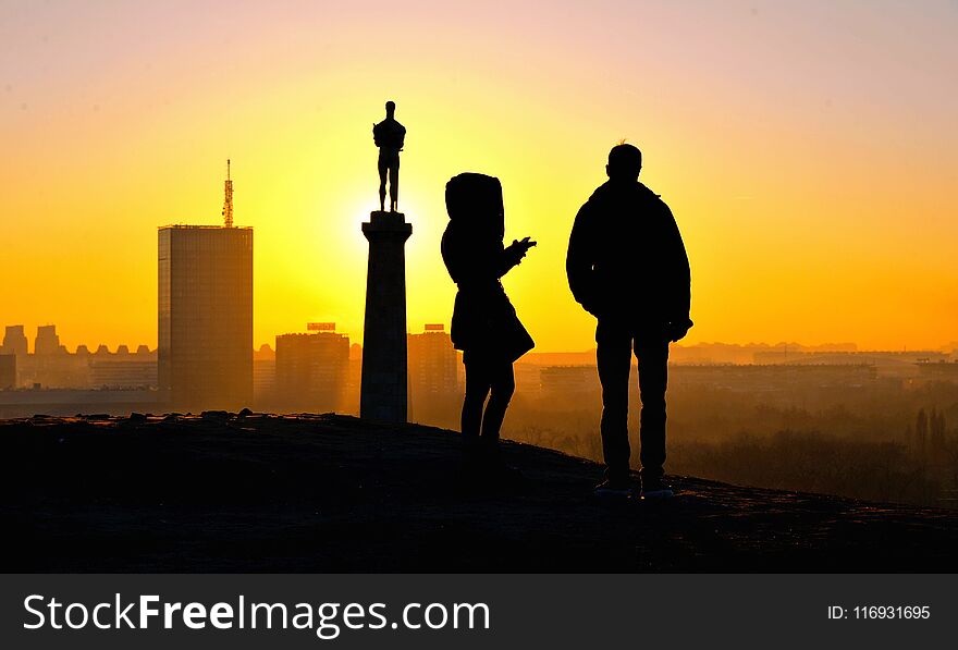 Silhouettes of people on warm colorful sunset with Danube river in Belgrade, Serbia. Silhouettes of people on warm colorful sunset with Danube river in Belgrade, Serbia