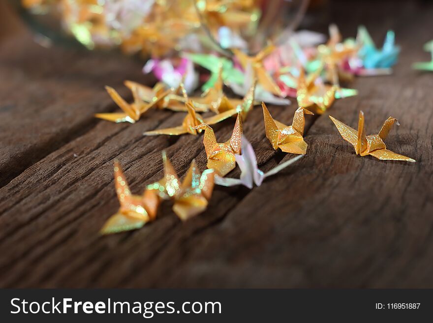 Origami paper bird on wooden background