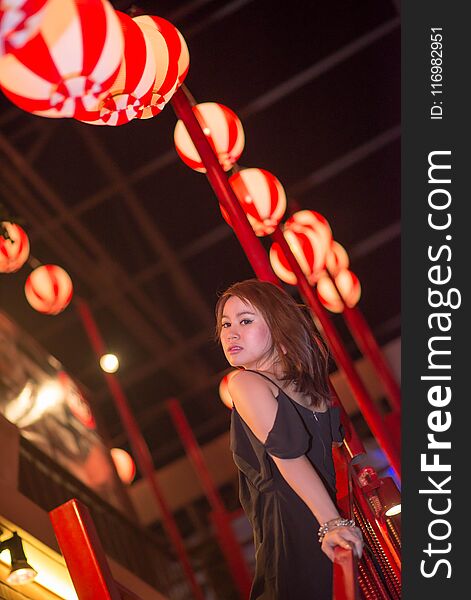 Young beautiful woman outdoor portrait,wear a luxury black dress in nightlife.