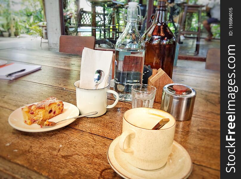 Coffee, latte, drinking water and sweets are placed on a wooden table. For breakfast. Coffee, latte, drinking water and sweets are placed on a wooden table. For breakfast