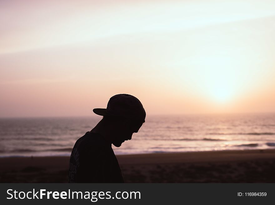 Silhouette of Man Wearing Cap at the Beach