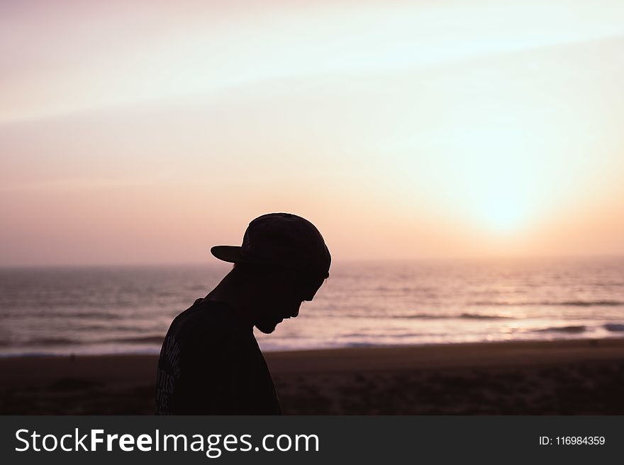 Silhouette Of Man Wearing Cap At The Beach