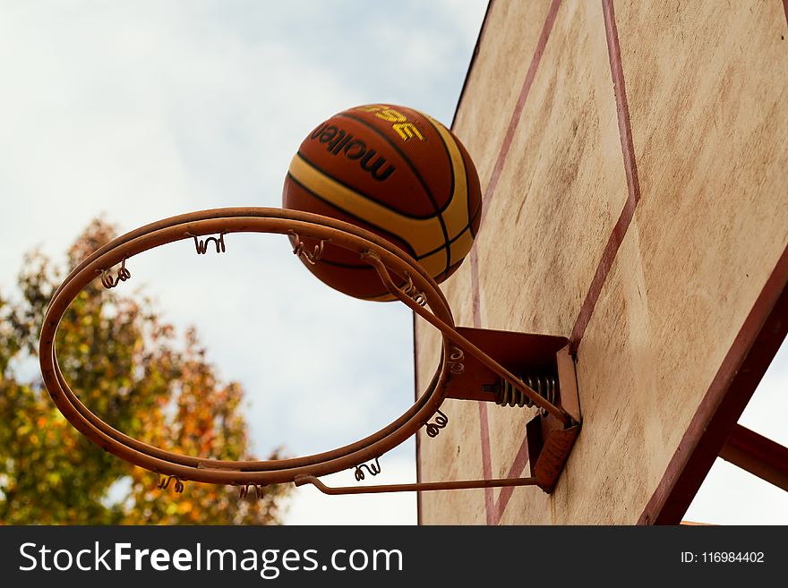 Brown Basketball Above Steel Basketball Hoop