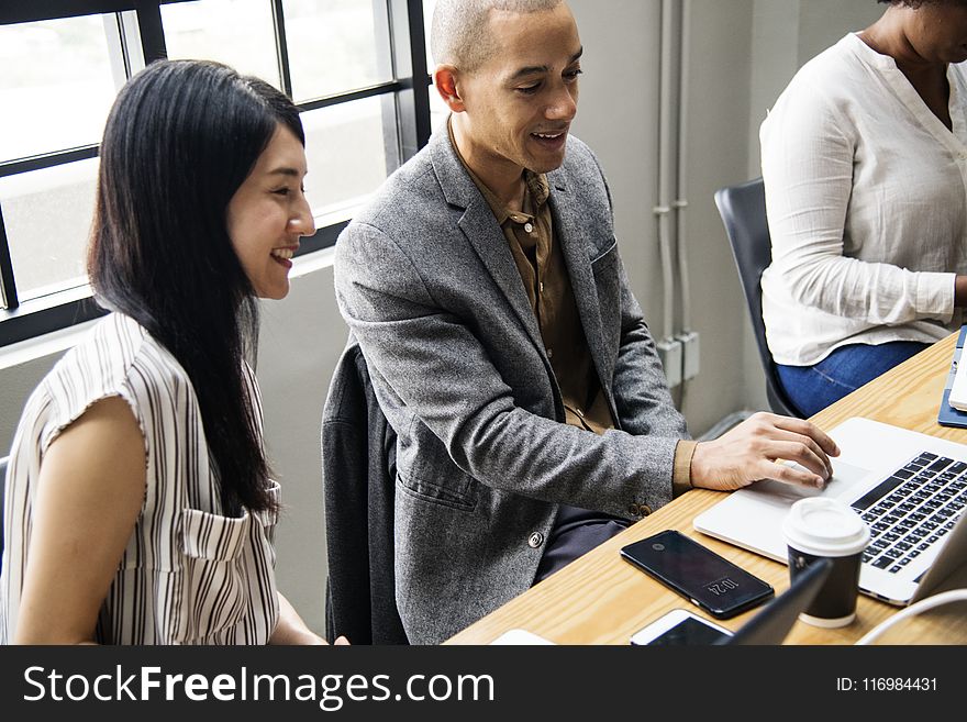 Photo Of Man And Woman Looking At Laptop