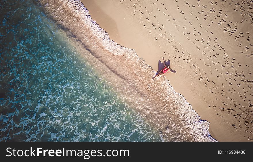 Photo of Person Lying Beside Seashore
