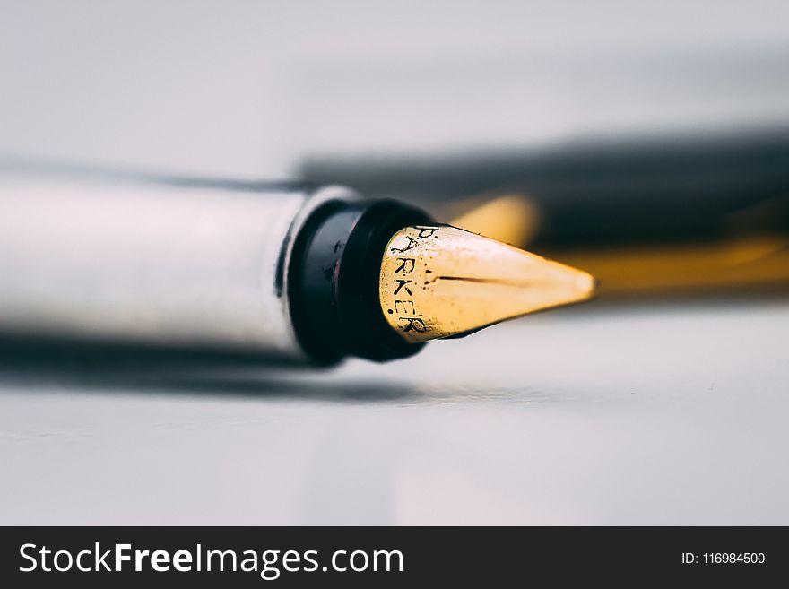 Selective Focus Photography of Fountain Pen on White Surface