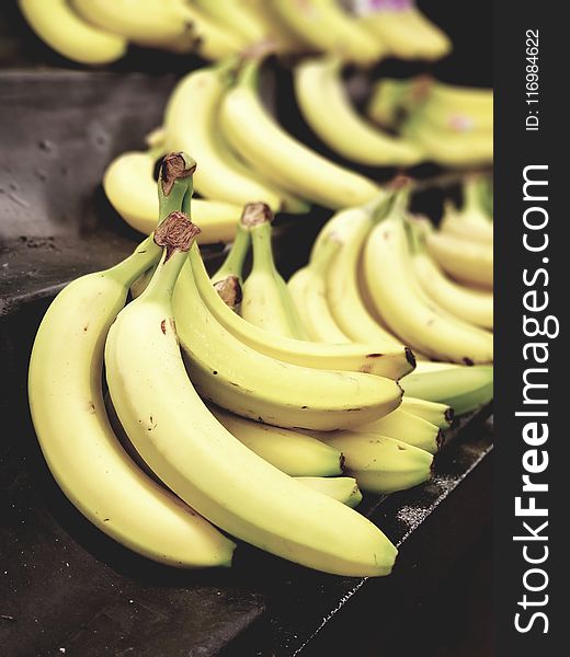 Selective Focus Photo of Bunch of Bananas on Black Surface