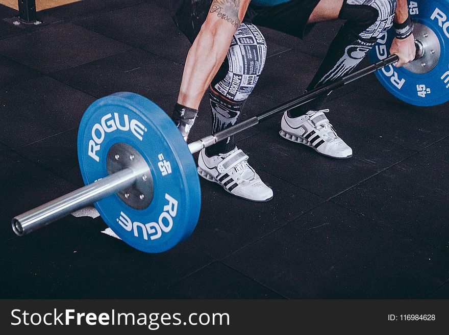 Man With Lift Stance Holds Blue Rogue Adjustable Barbell