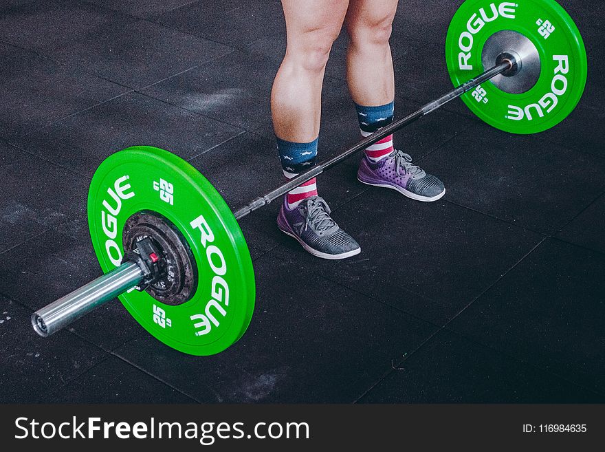 Person Standing in Front of Green and Gray Barbell