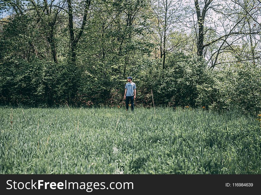 Photography of a Man Standing on Grass Field