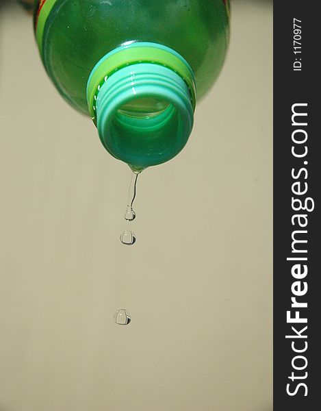 Water drips from a green bottle. Water drips from a green bottle.