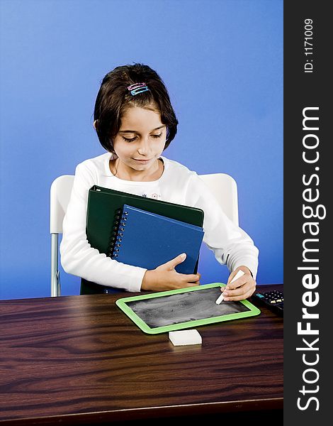 Little girl writing on chalkboard in classroom. Little girl writing on chalkboard in classroom