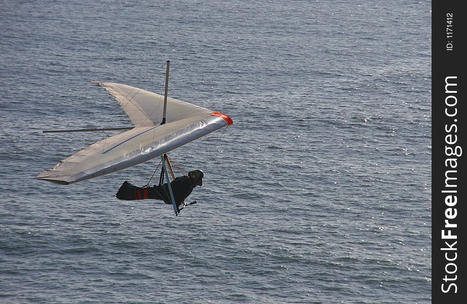Hang glider flies over the ocean. Hang glider flies over the ocean