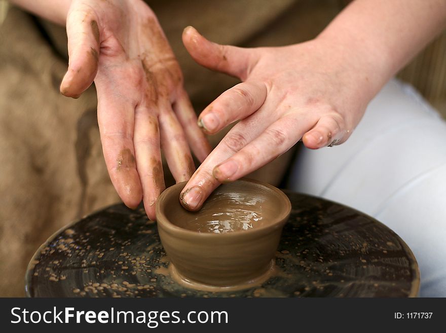 Close-uo of potter's hands making a dish