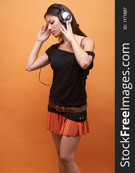 Girl with long dark brown hair, black top, orange miniskirt and headset. Girl with long dark brown hair, black top, orange miniskirt and headset