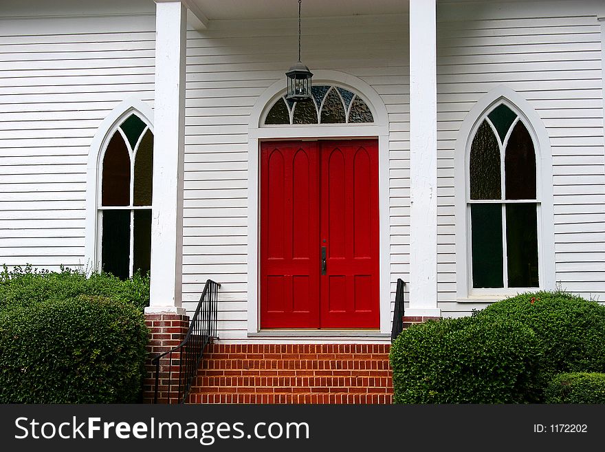 Red door on white church