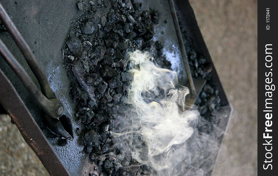 The tools of a medieval blacksmith next to hot embers. The tools of a medieval blacksmith next to hot embers.