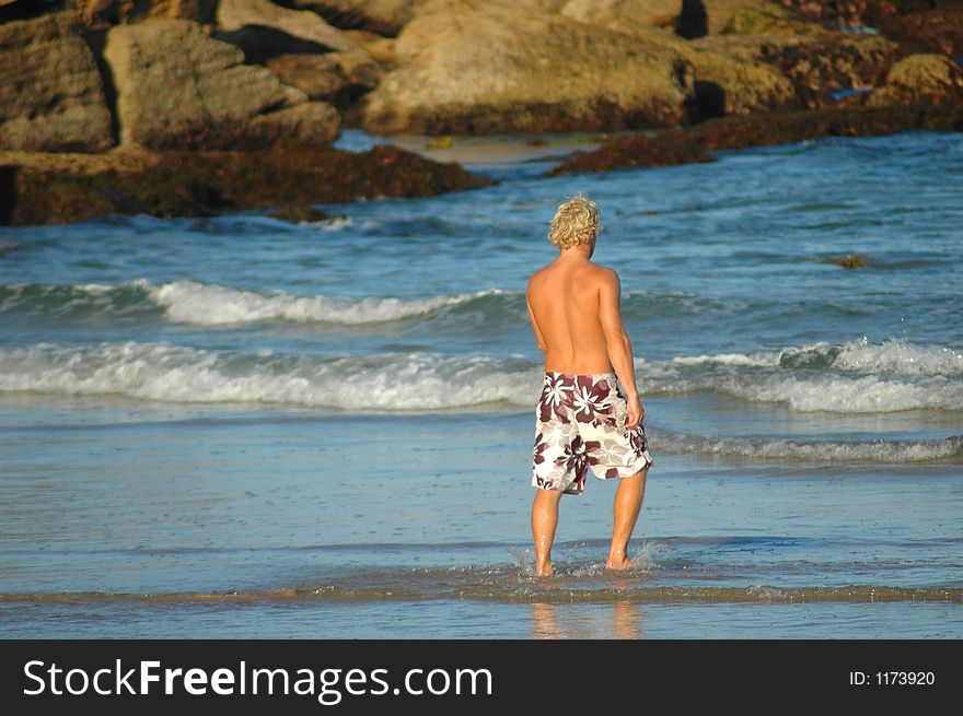 Blond man walking into ocean. Blond man walking into ocean