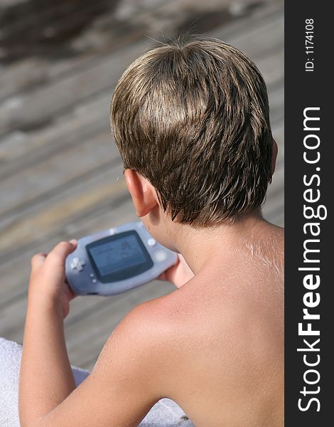 Young Boy playing video game on dock